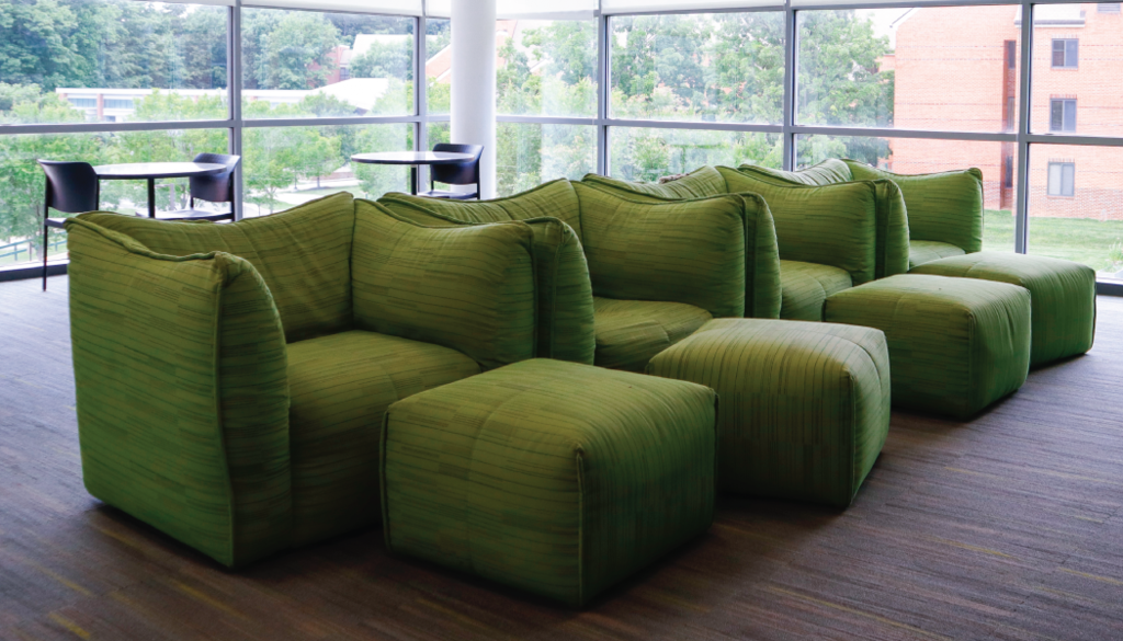 Taylor Hall common room at George Mason University with modern green lounge chairs and natural lighting
